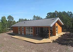 Flot, nyt luksussommerhus i træ, bygget i 2006. Huset er beliggende i et fredeligt naturområde med plantage og med god afskærmning mellem husene. Til huset hører et stort åbent samt overdækket t ...
