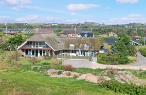  I naturskønne omgivelser mellem Hvide Sande og Søndervig ligger dette særligt attraktive luksushus på en kuperet klitgrund. Med sine 400 m² egner det sig perfekt til flere familier. Huset indeho ...