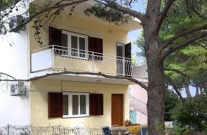  Dette enkelt indrettede feriehus indeholder to lejligheder, der er forbundet med en udendørs trappe. Huset ligger i nærheden af havet og på grunden står flere pinjer der byder på skygge på varm ...