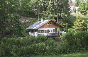  Dette hyggeligt og komfortabelt indrettede feriehus ligger uforstyrret i udkanten af en skov. Lige foran døren er der en lille badesø (100 x 150 m). Til hyggestunder står der en pejs i stuen. I sa ...