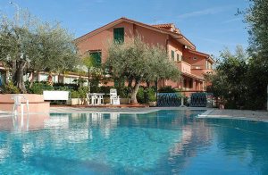  Feriekompleks beliggende på en 12.000 m2 stor grund med haver og olivenlunde og udsigt til havet og de omkringliggende høje. Komplekset råder over 3 swimmingpools, tennis, minigolf og restaurant. ...