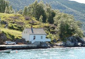  Feriehus med komfortabelt møblement. Bade- og fiskemuligheder fra den store terrasse som er bygget udover søen. Fredelig beliggenhed i en rolig bugt midt i Åkrafjorden, helt afskærmet med enestå ...