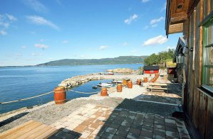  Feriehus af høj standard beliggende sammen med et par andre hytter langs breden af Storfjorden. Lige ved feriehusene er der bygget en kunstig, afskærmet bugt med fælles tømmerflåde og båd. 75 k ...