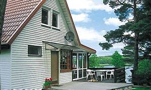  Halvdel af dobbelthus med altan og overdækket terrasse. Det ligger direkte ud til en sø. Stejl trappe. PMA212 i anden halvdel. ...