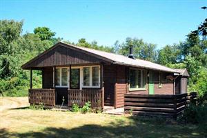 Älteres Ferienhaus aus Holz, 1970 gebaut, auf einem Naturgrundstück nur 100 m vom Wasser entfernt gelegen. Offene Terrasse und mit Gartenmöbeln. Neues Badezimmer (1999) mit Duschnische und Waschmas ...