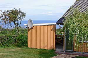 På en dejlig naturgrund på en blind vej ligger dette sommerhus i træ, renoveret og tilbygget i 1993, som er udstyret med spa og sauna. Fra stuen er der en flot udsigt over markerne og fjorden. Træ ...