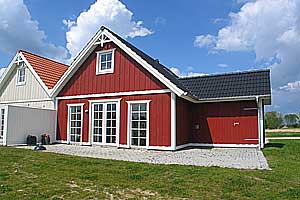 Von einem Architekten gezeichnetes Endreihenhaus aus Holz in 2 Etagen, 2003 gebaut. Vom Haus gibt es Blick auf einen kleinen See und vom Balkon im Obergeschoss ist das Meer zu ahnen. Offene Terrasse m ...