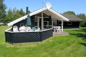 Sommerhus i træ, bygget i 1996, beliggende på en større naturgrund. Til huset hører såvel åbent som overdækket terrasseareal med havemøbler. Indvendigt er huset indrettet med mørkt trægulv,  ...